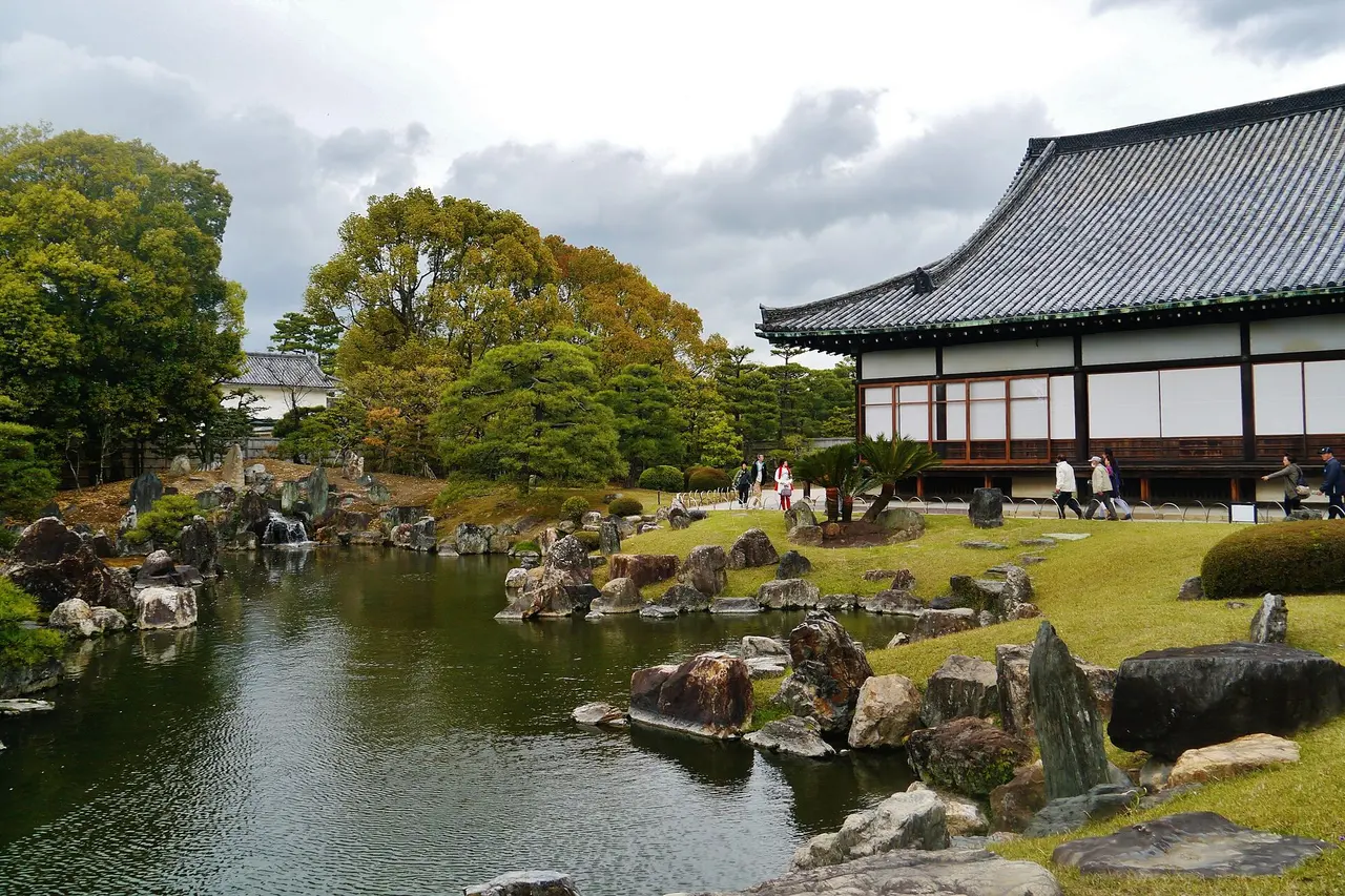 The pond of the Ninomaru Garden at Nijo Castle, with rocks and clipped trees and a palace building on the right