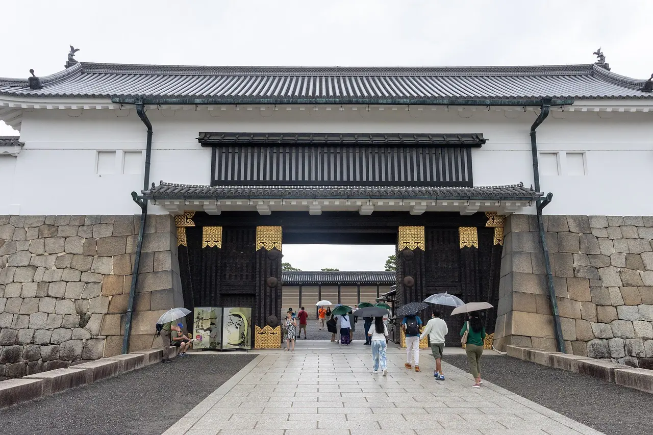 The Higashi Ote-mon, Nijo Castle's East Gate, a heavy white-walled gatehouse on a stone base with black doors studded in gold